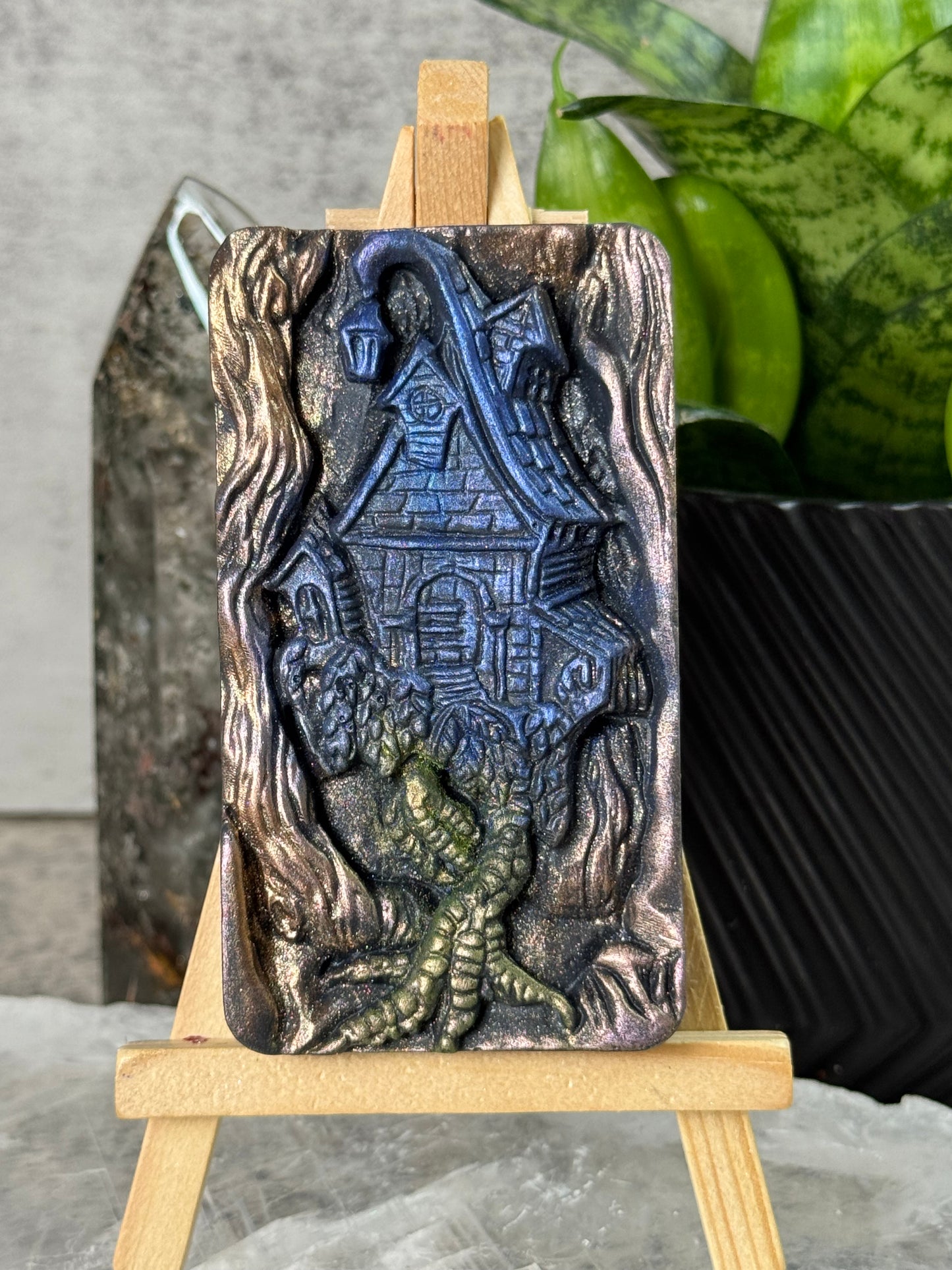 Decorative metal belt buckle with intricate design on a stand