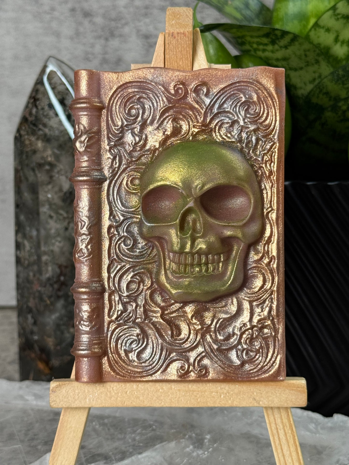 Decorative metal box with skull design on a stone surface