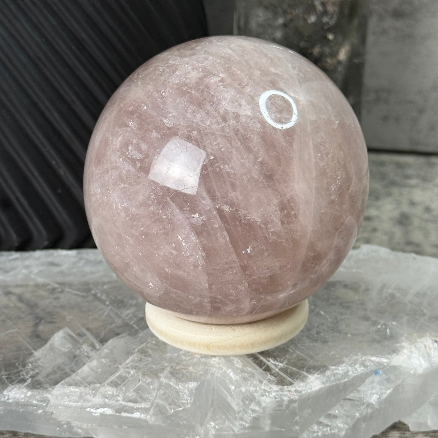 Round stone object with a white circular mark on a textured surface