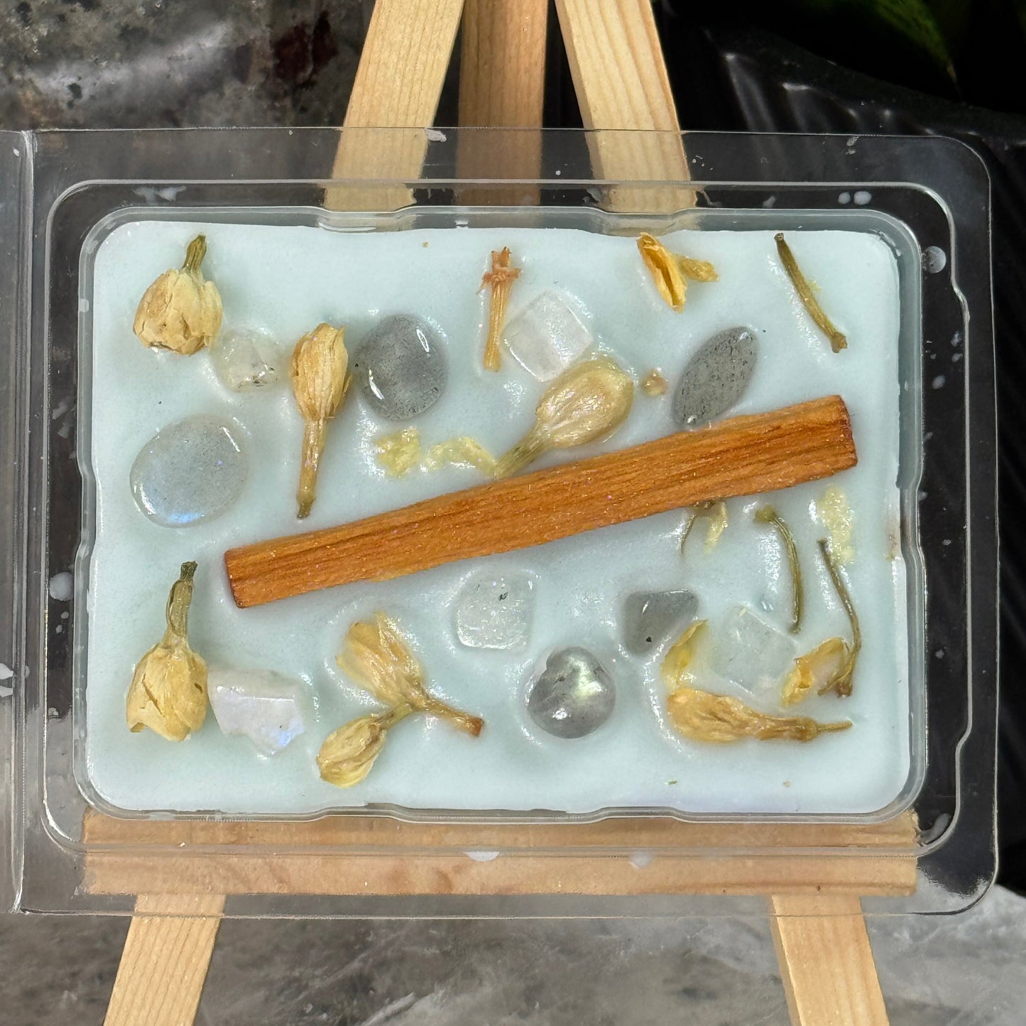 Mold with dried herbs and cinnamon sticks on a stone surface