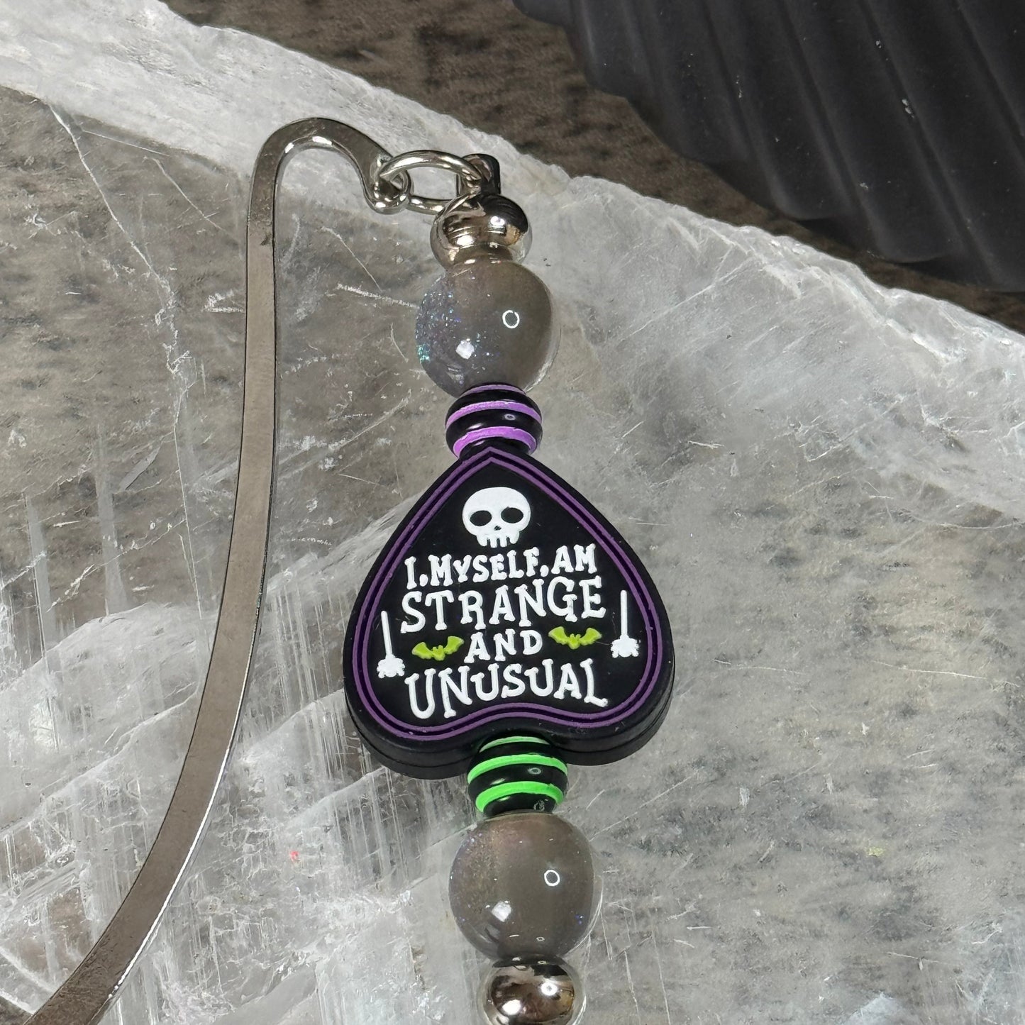 Decorative keychain with a purple heart-shaped tag on a textured surface