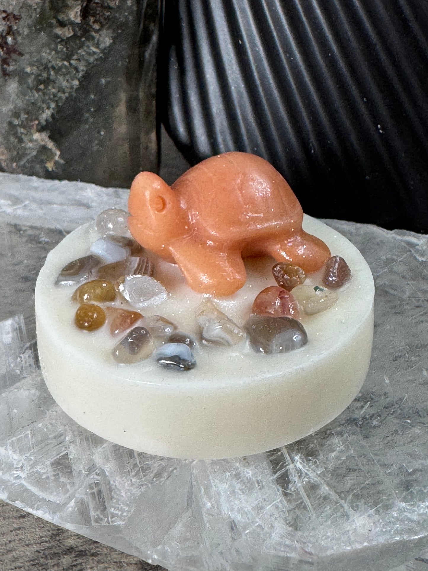 Soap mold with a small figurine and embedded stones on a textured surface