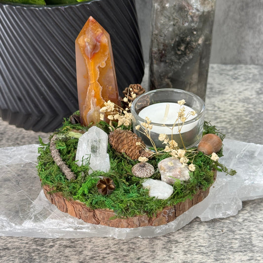 Decorative arrangement with moss, stones, and a small clock on a stone surface