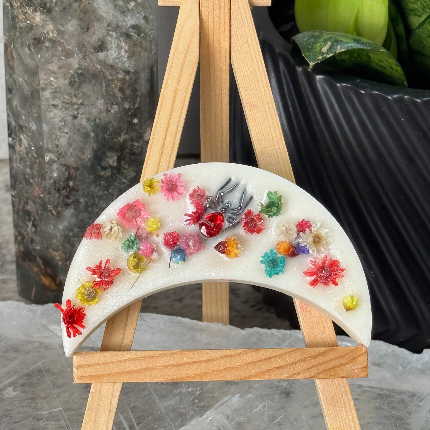 Decorative moon-shaped tray with floral designs on a marble surface