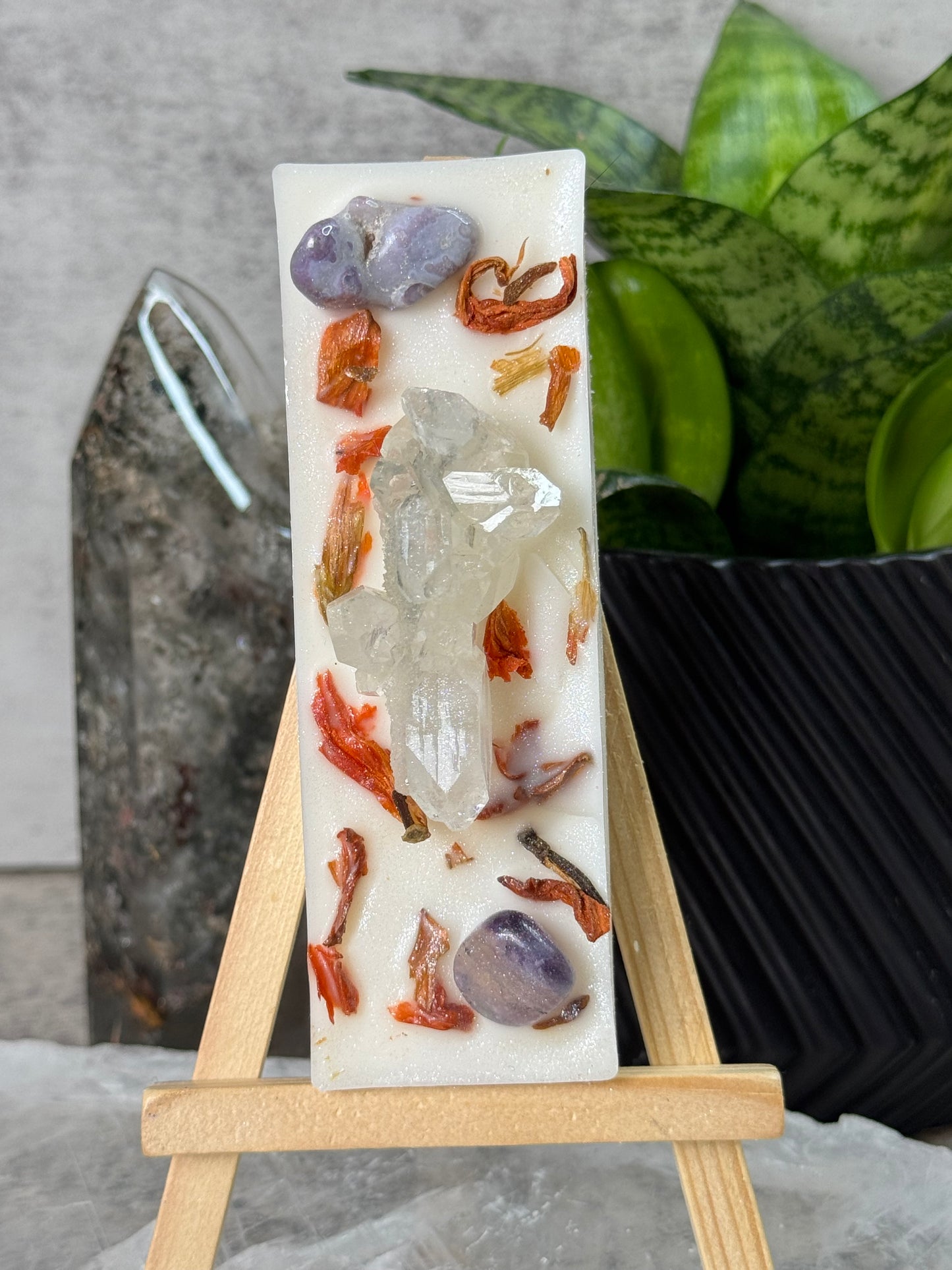 Decorative soap bar with embedded stones on a wooden stand against a neutral background