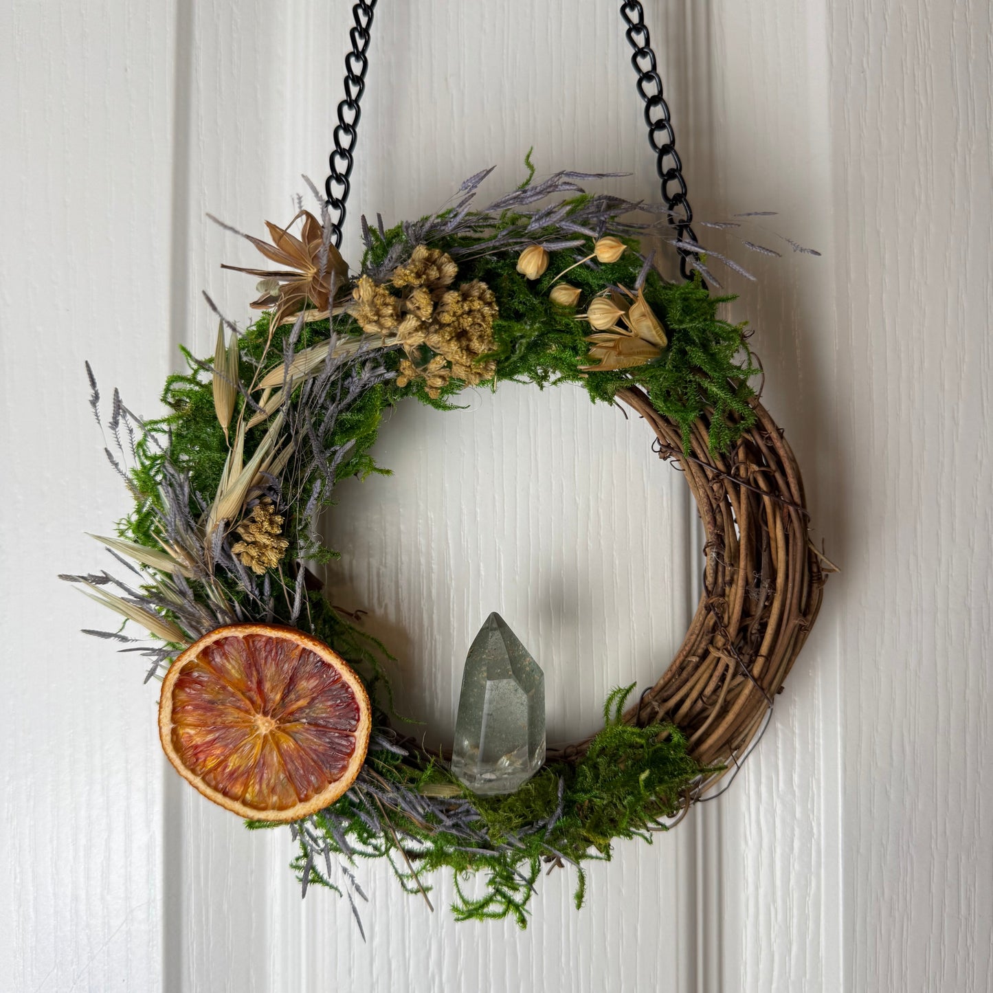 Decorative wreath with natural elements hanging on a door