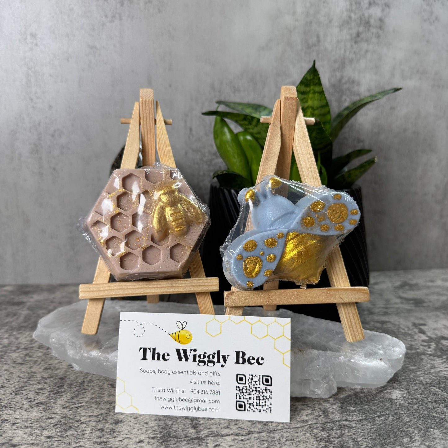 Two small wooden stands with decorative items and a business card on a gray surface.