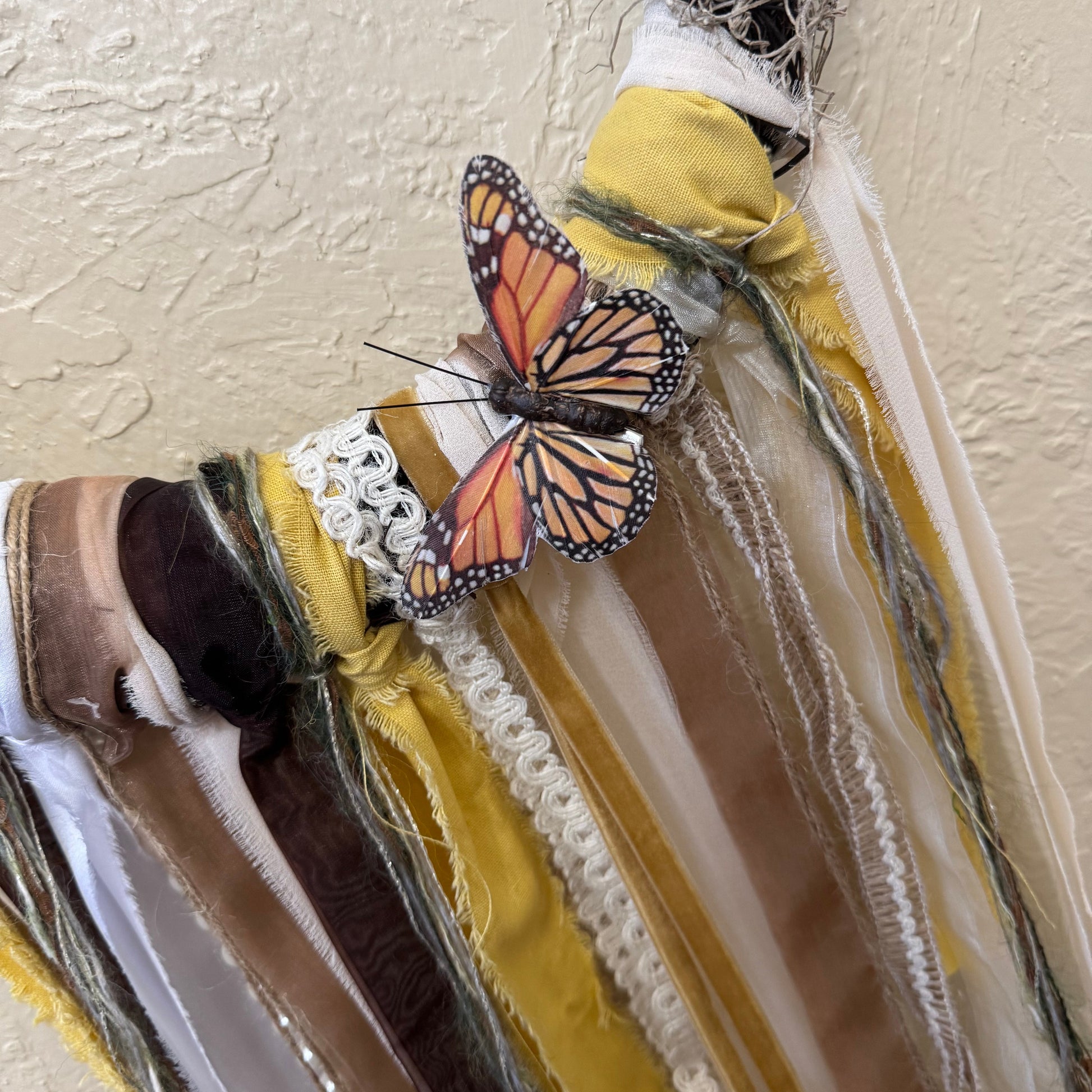 Butterfly on a textured surface with feathers and fabric