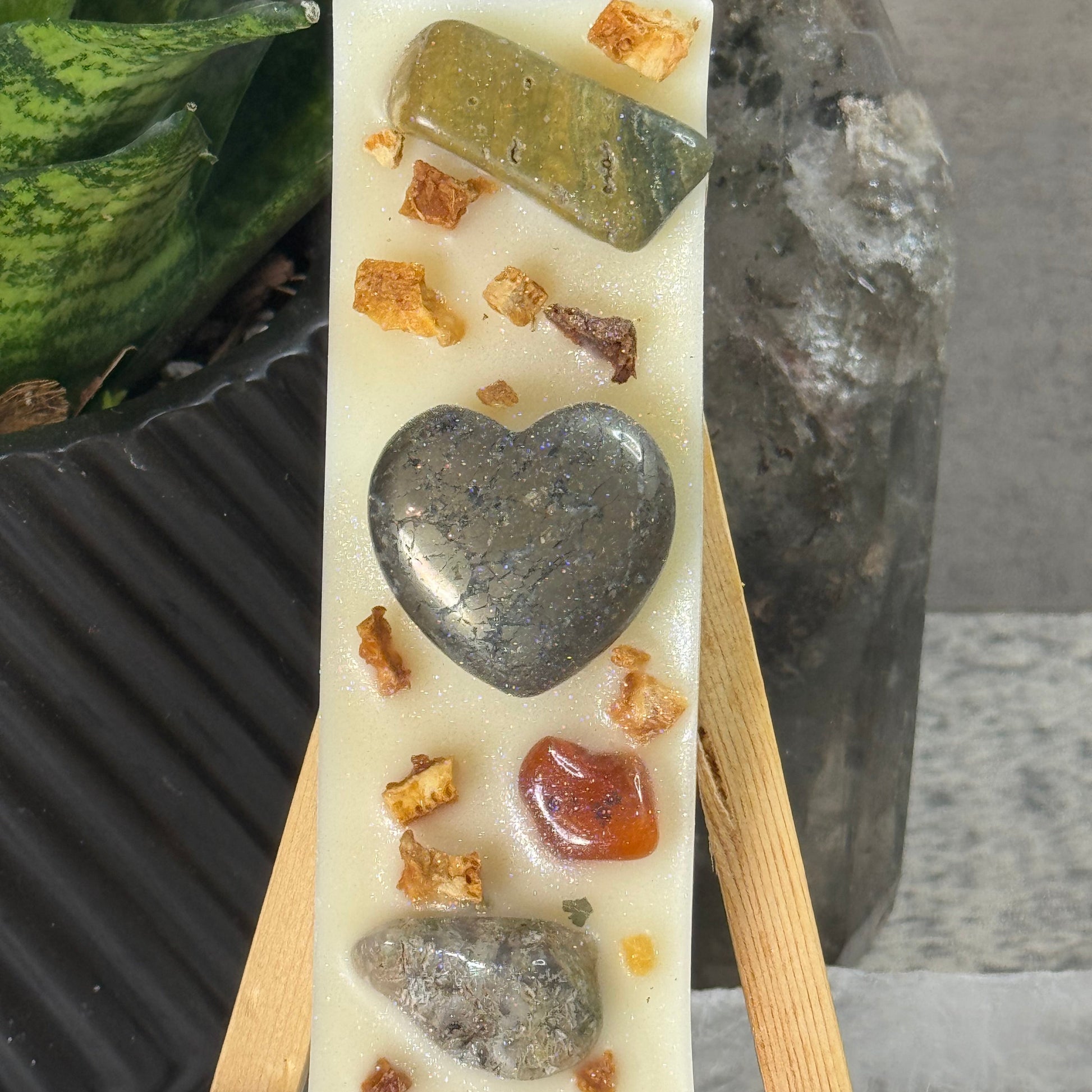 Decorative soap with embedded stones on a wooden stand against a neutral background
