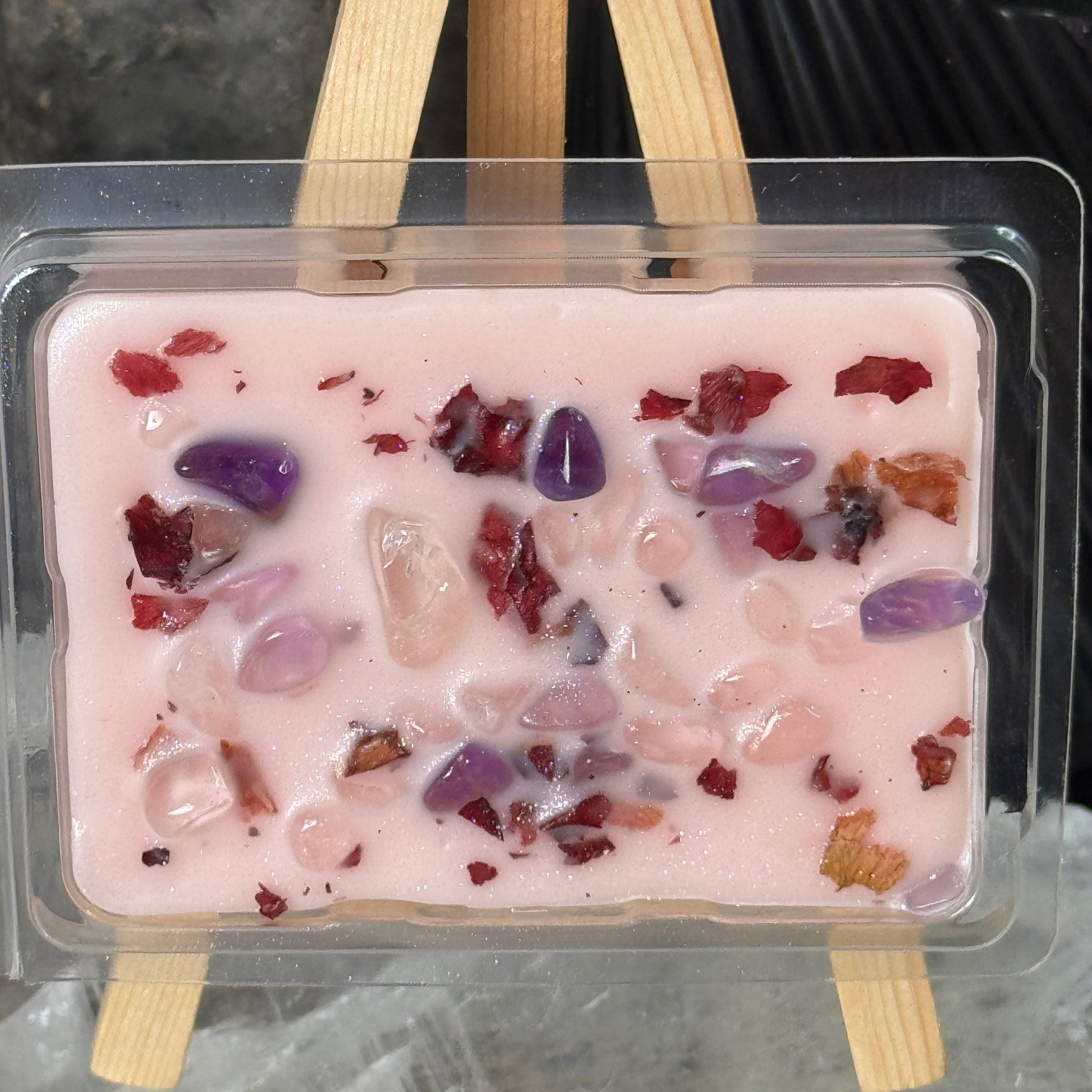 Popsicle mold with pink popsicle mixture and visible ingredients on a gray surface