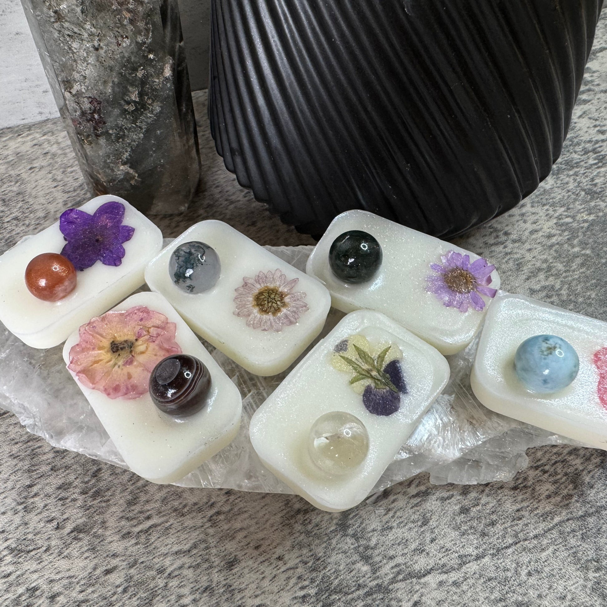White rectangular stones with embedded flowers and stones on a stone surface