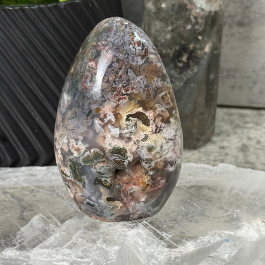 Rusty metal object on a concrete surface with a plastic bag in the background