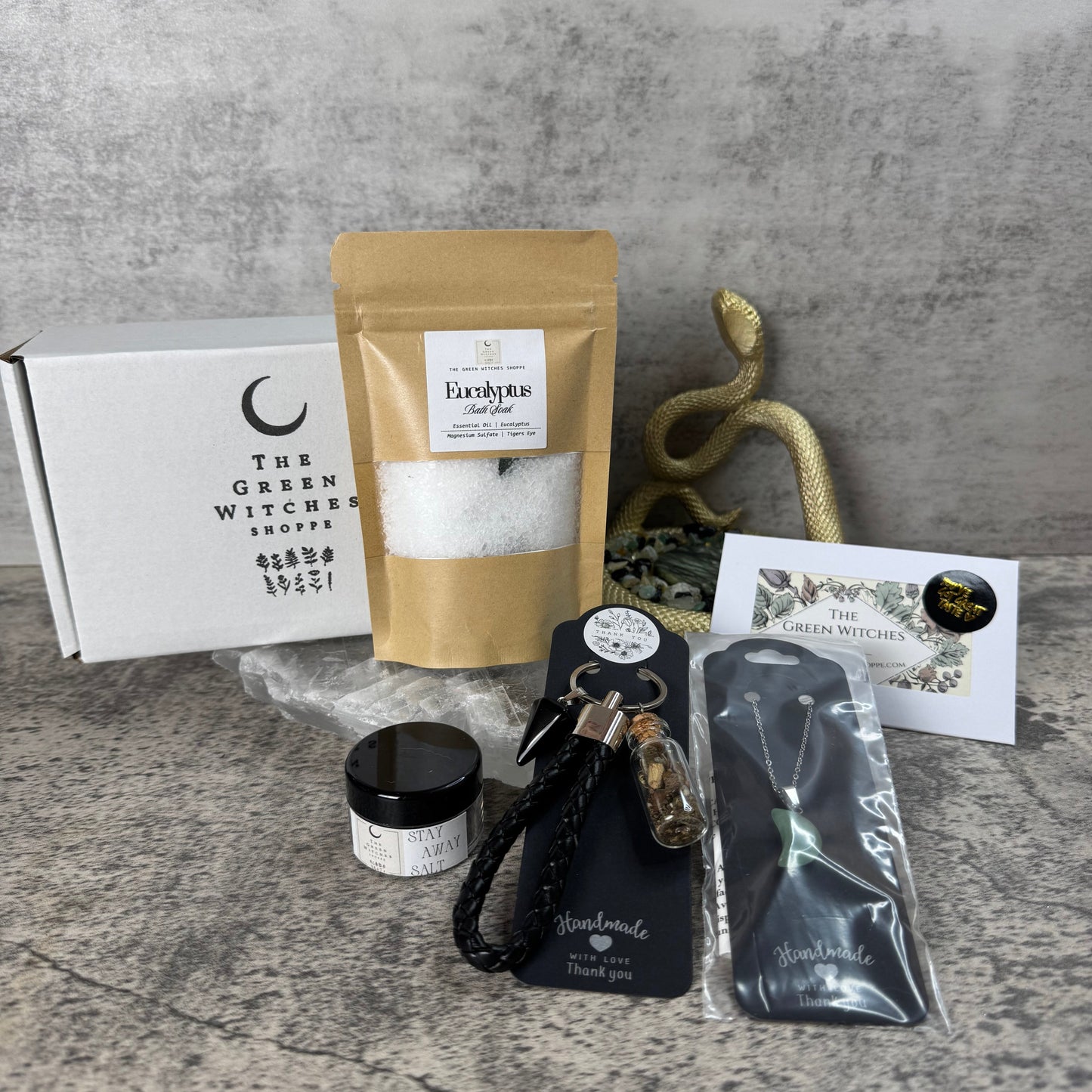 Collection of items including a bag, keychain, and packaging on a textured surface.