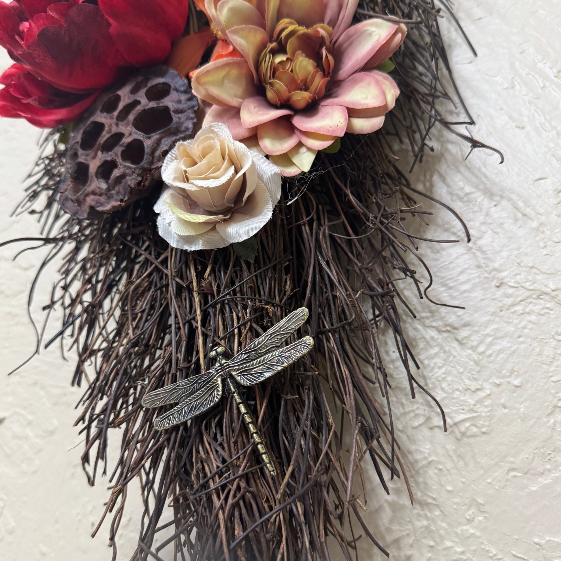 Decorative wreath with flowers and branches on a textured white background