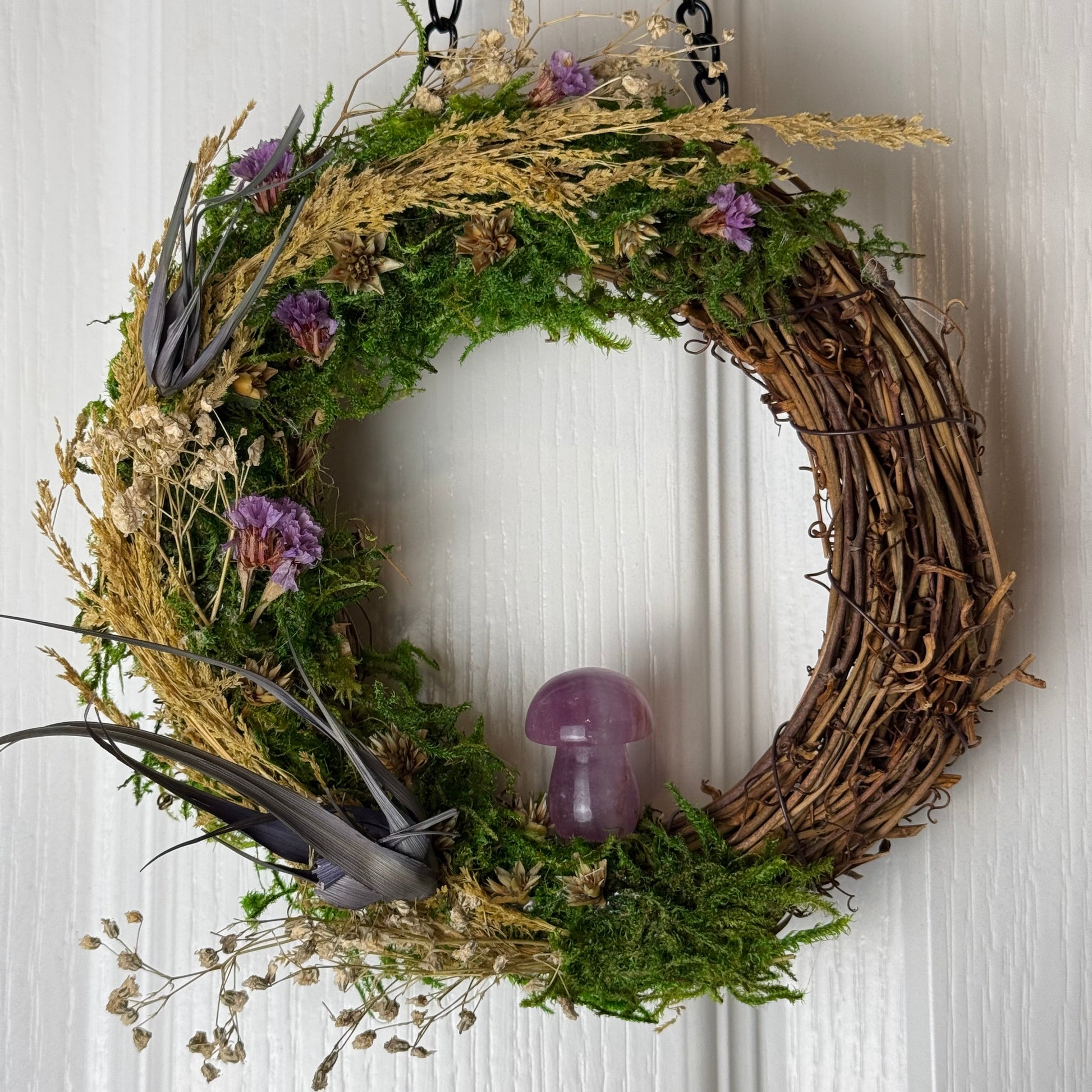 Decorative wreath with greenery and flowers on a white background