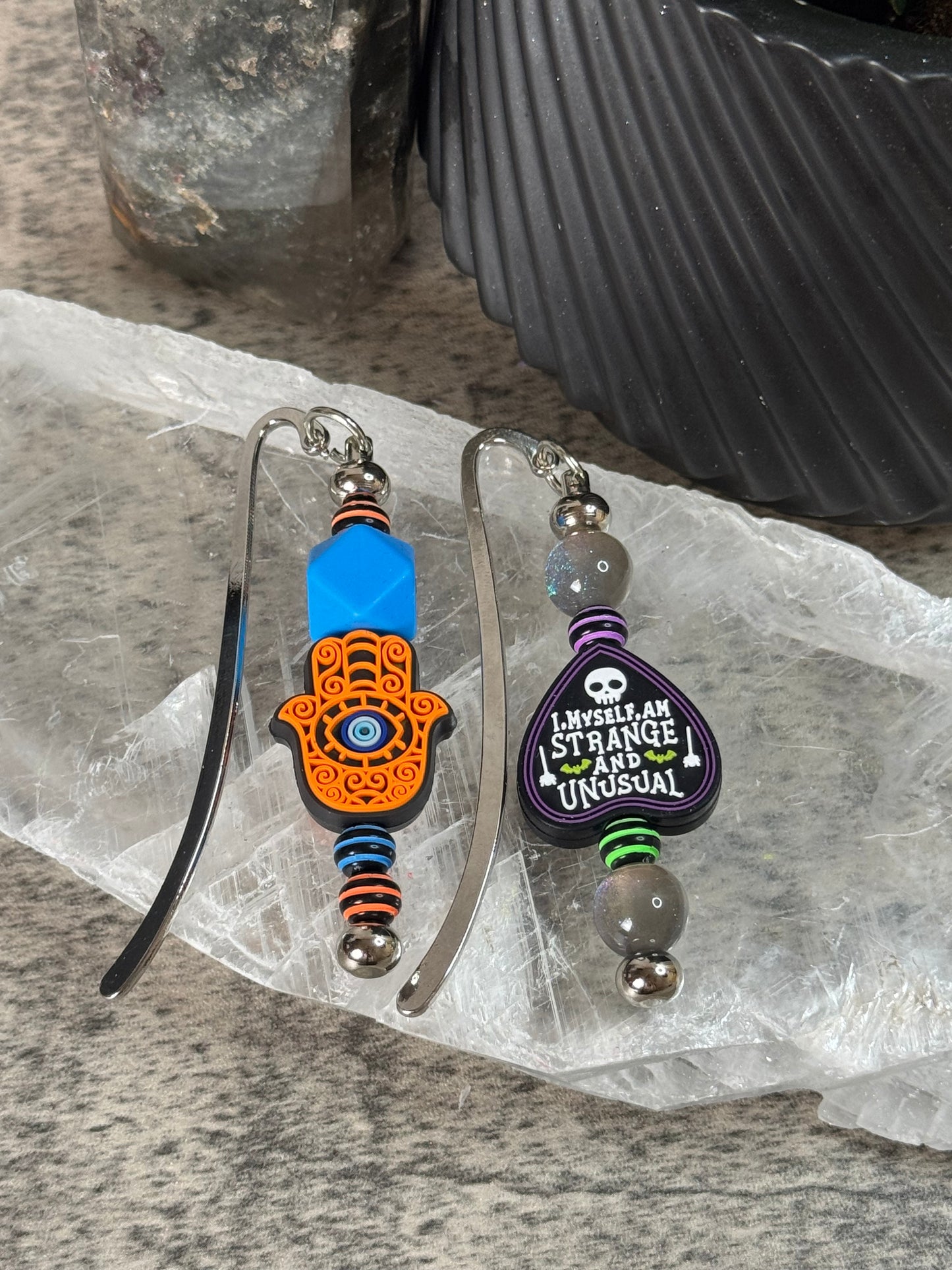 Two colorful keychains on a clear plastic sheet with a textured surface background.