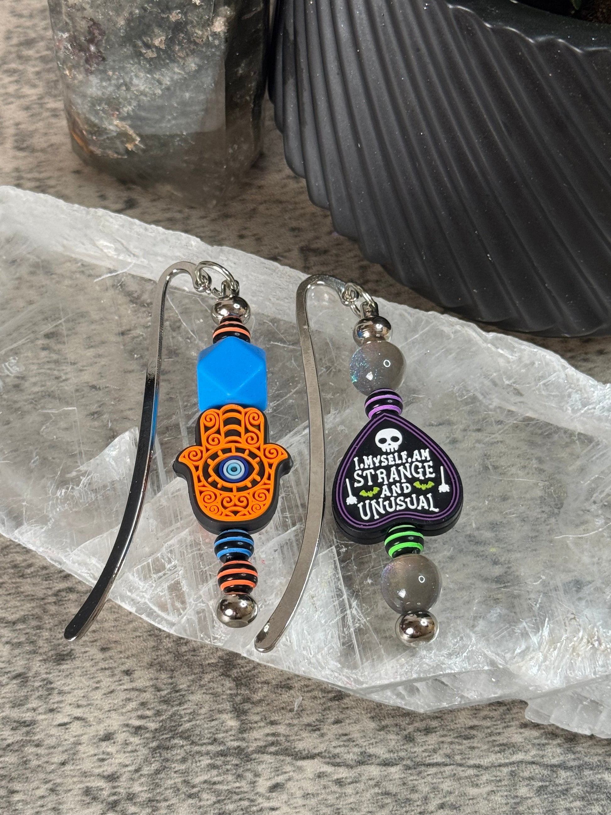 Two colorful keychains on a clear plastic sheet with a textured surface background.