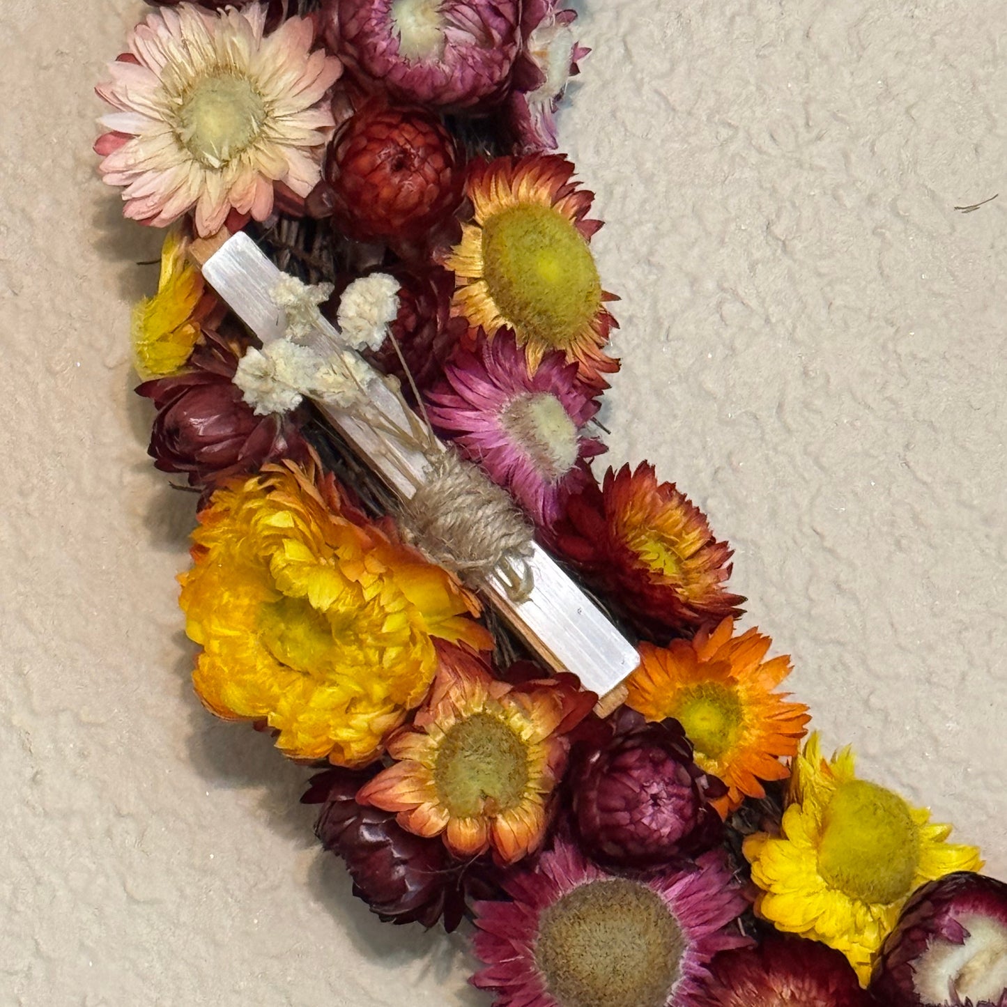 Dried flowers in various colors arranged on a textured surface
