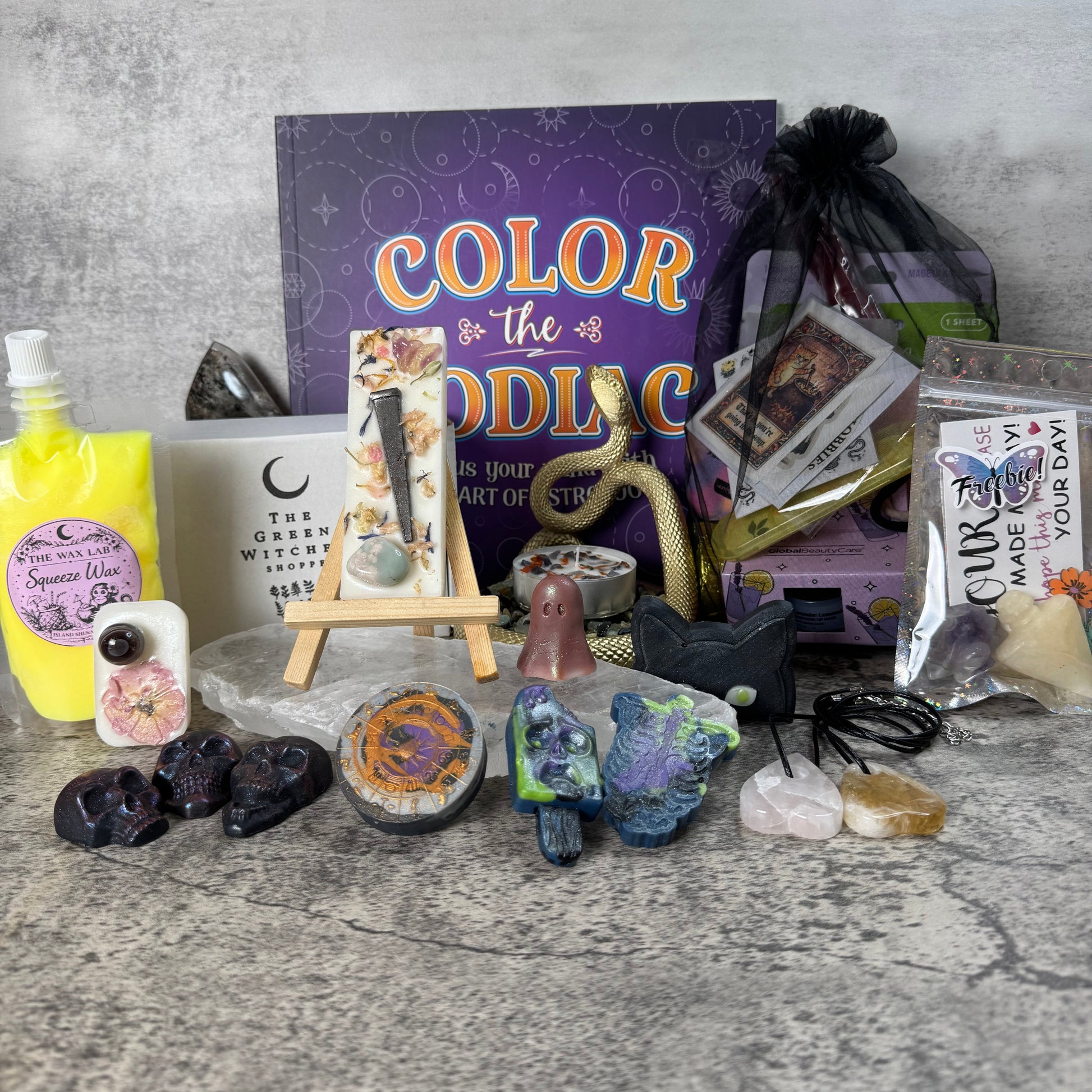 Collection of art supplies and decorative items on a textured surface with a 'Color the Odd One Out' book in the background.