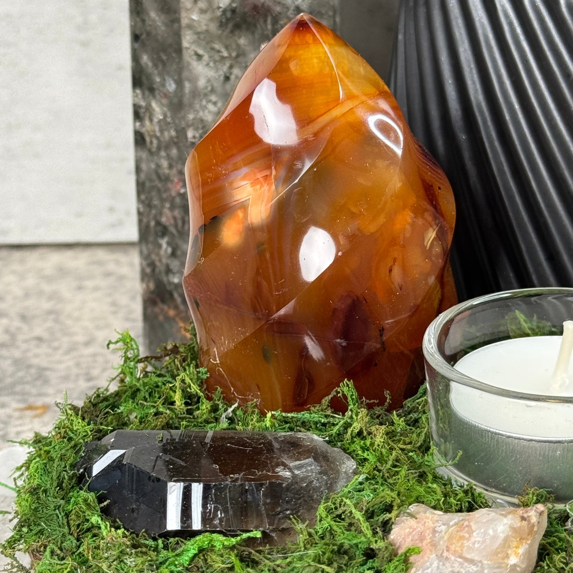 Agate stone and crystal on a natural background with a candle