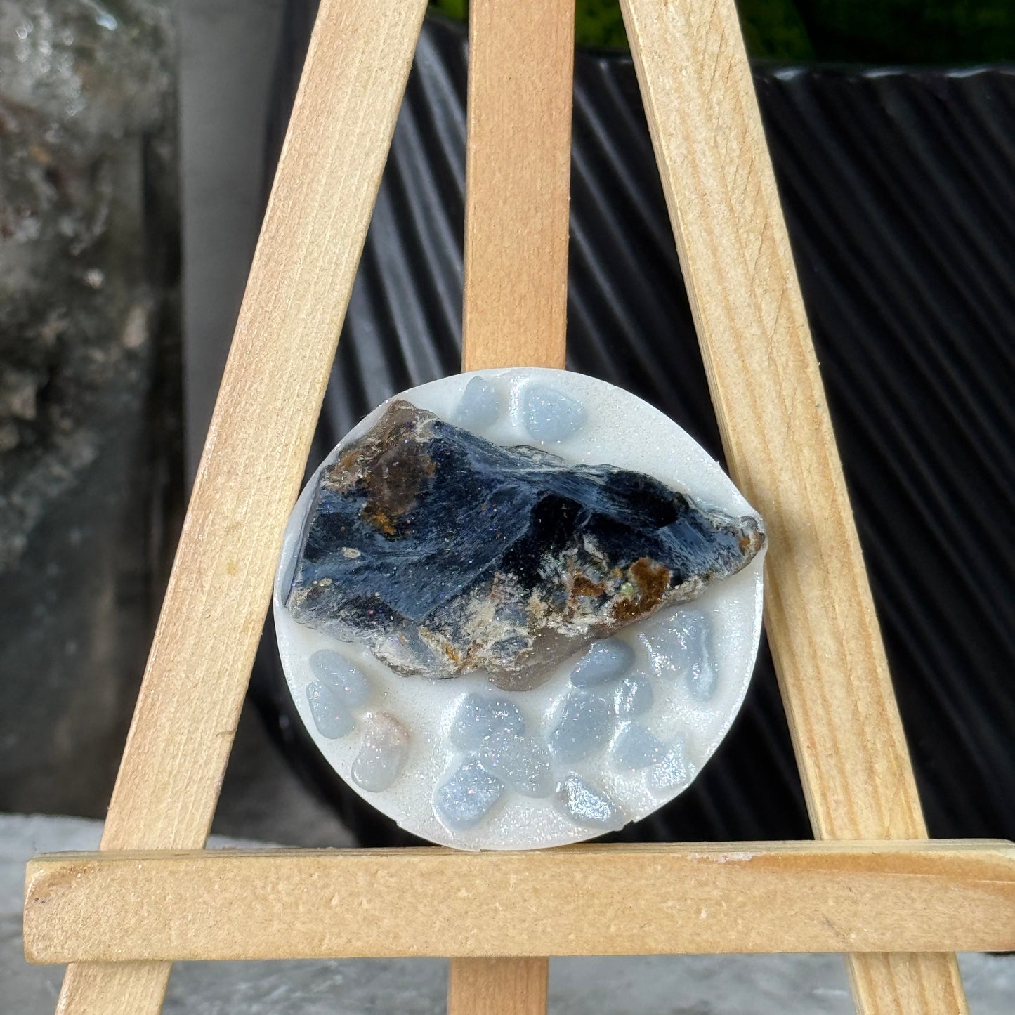 Close-up of a cylindrical stone with a rough texture on a wooden stand.