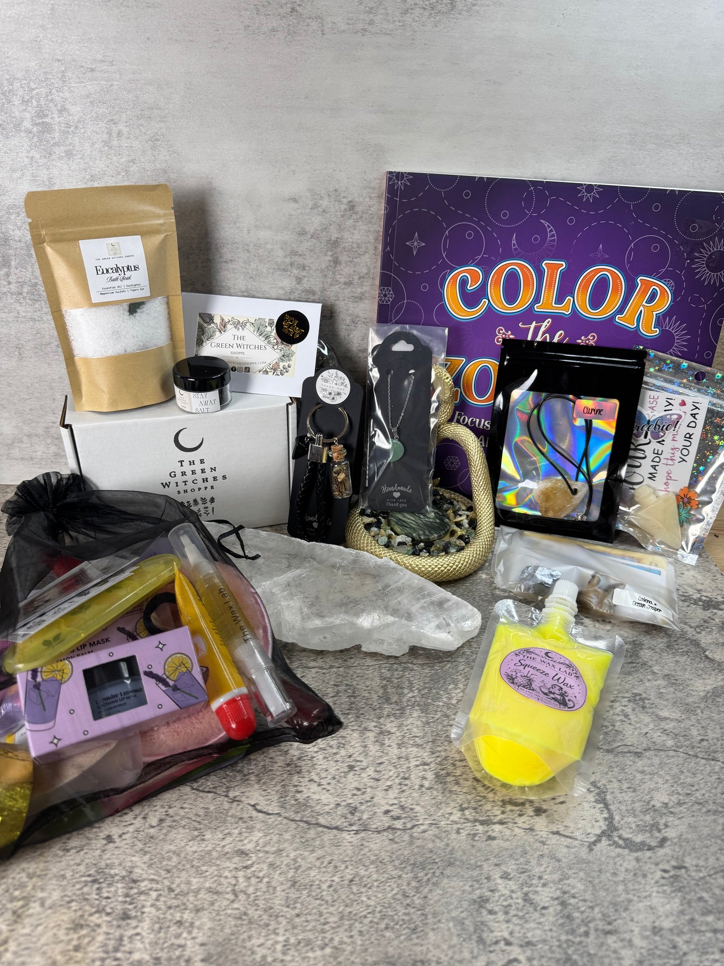 Collection of items including a bag, bottle, and cards on a gray surface.