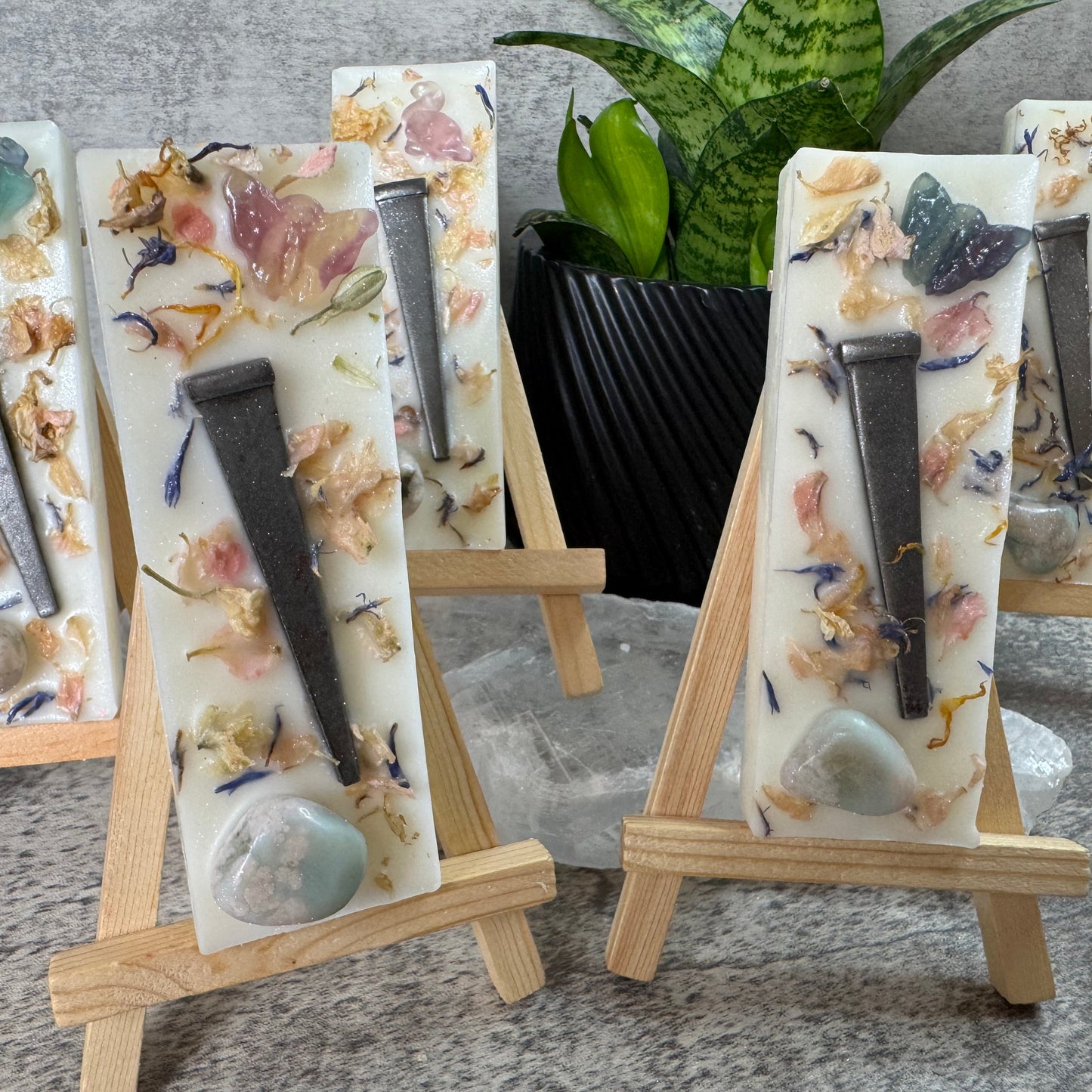 Decorative wall art pieces with tools and natural elements on small easels.