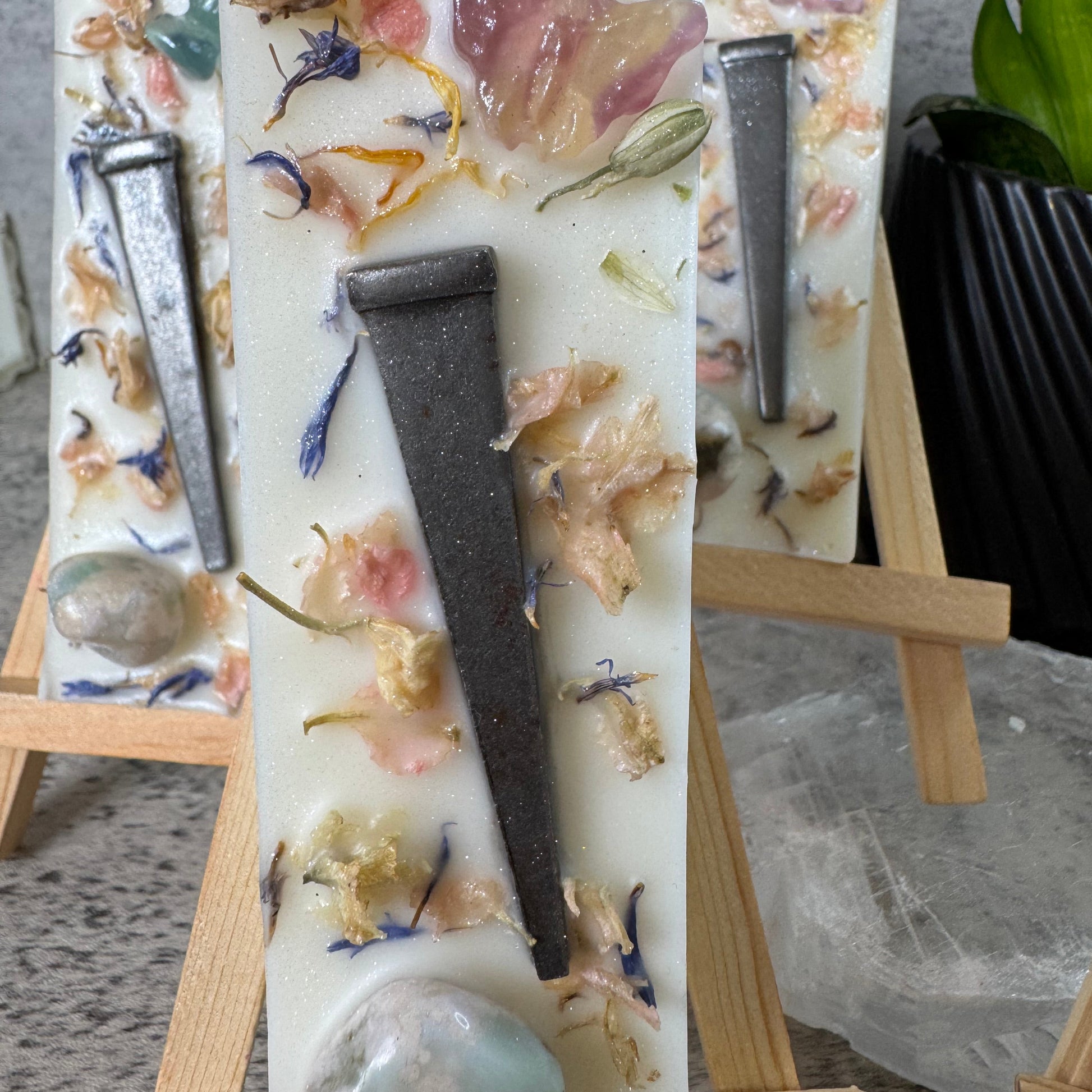 Decorative soap with floral and natural elements on a wooden stand.
