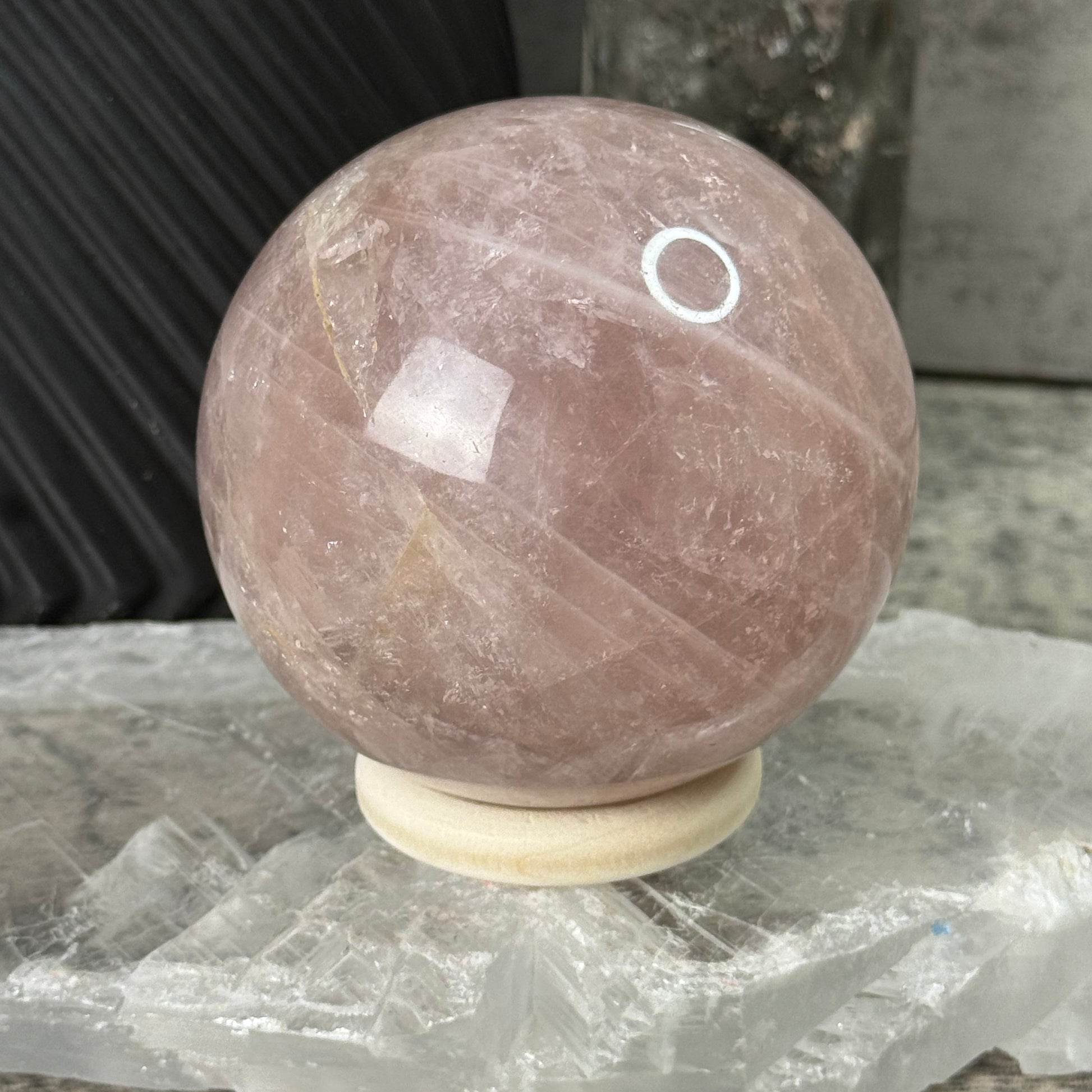 Round stone object with a white circular mark on a textured surface
