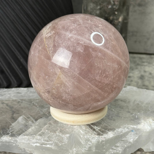 Round stone object with a white circular mark on a textured surface