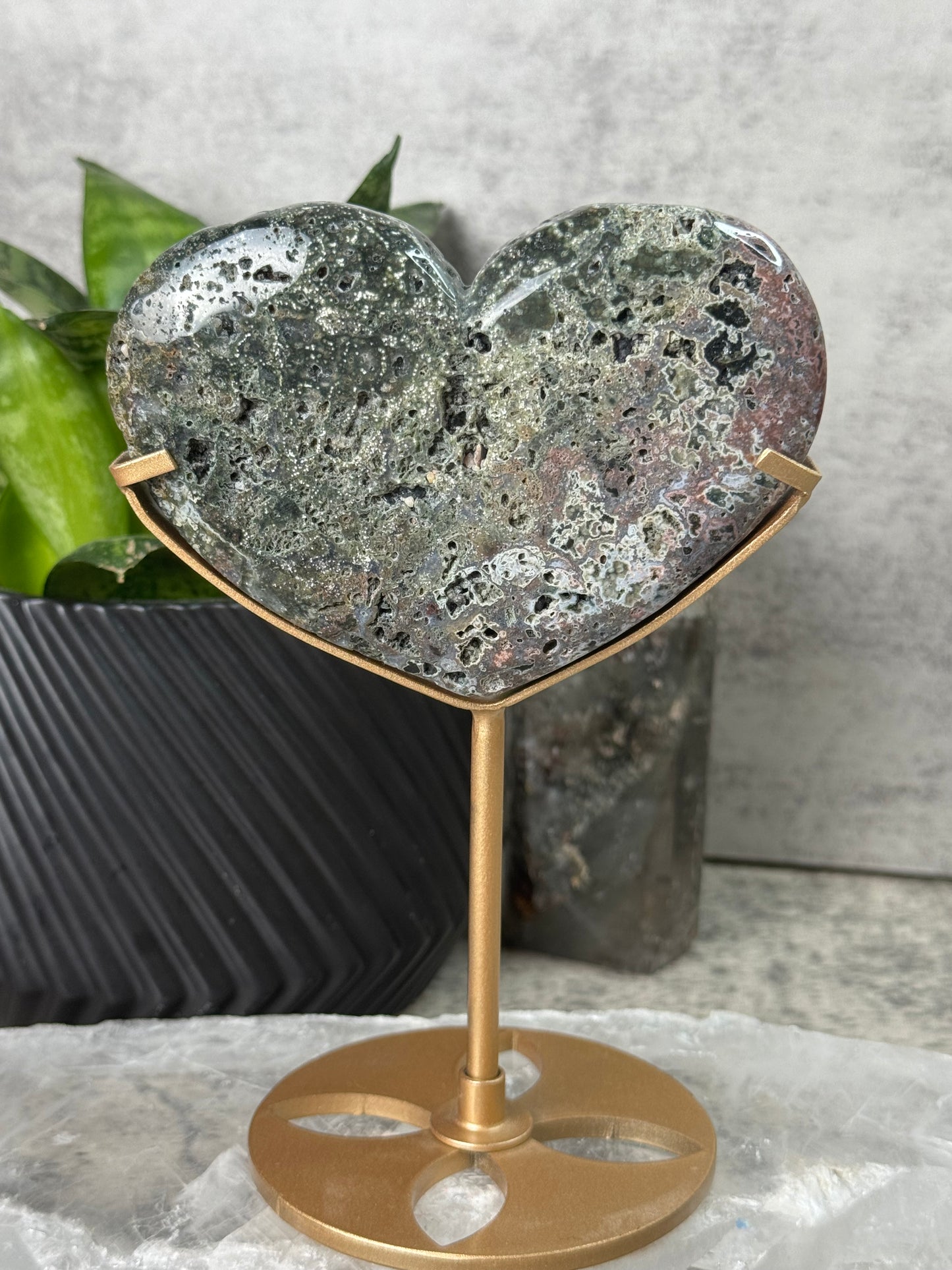 Decorative wall hook with textured stone design and gold finish on a neutral background