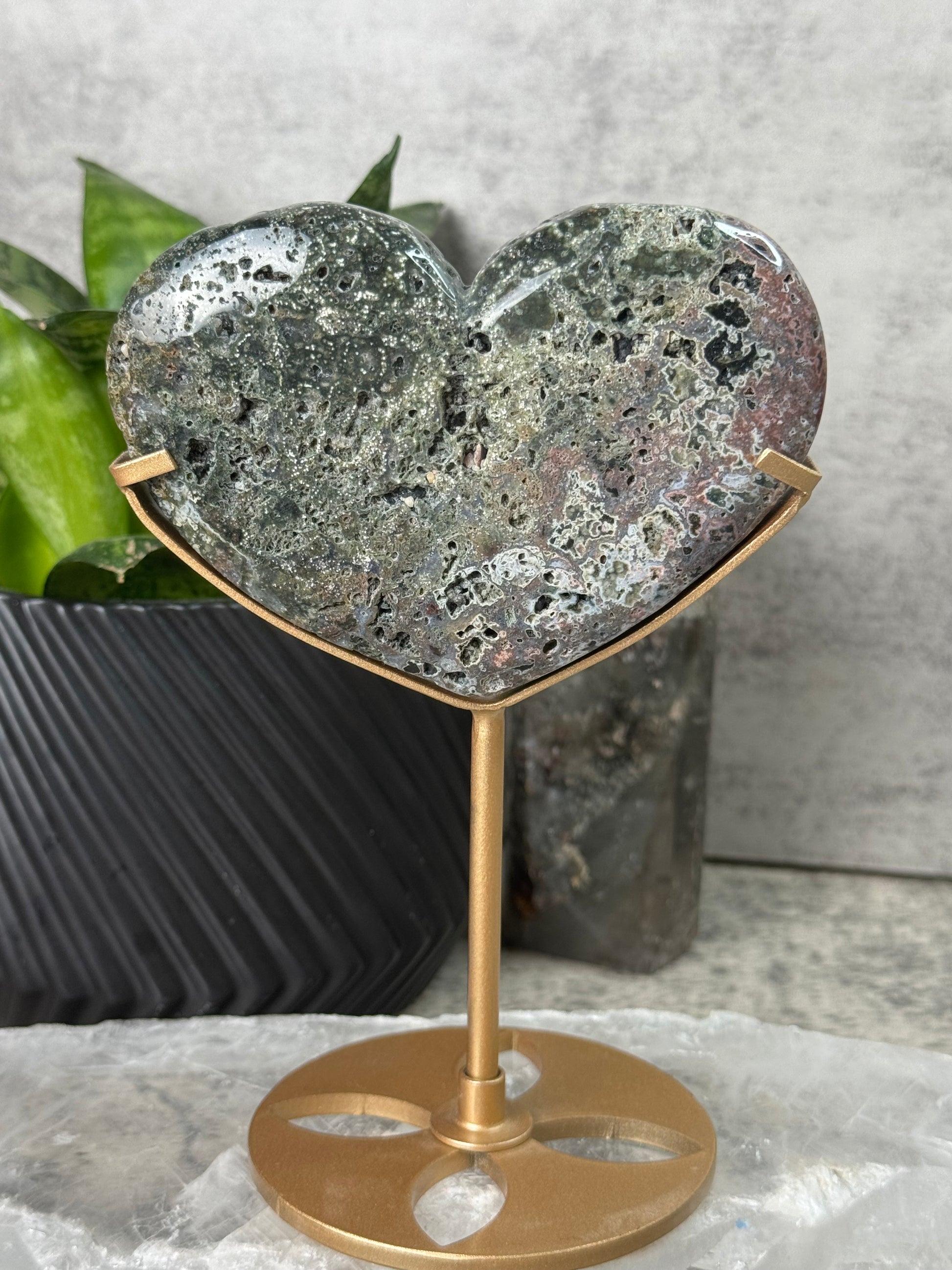 Decorative wall hook with textured stone design and gold finish on a neutral background