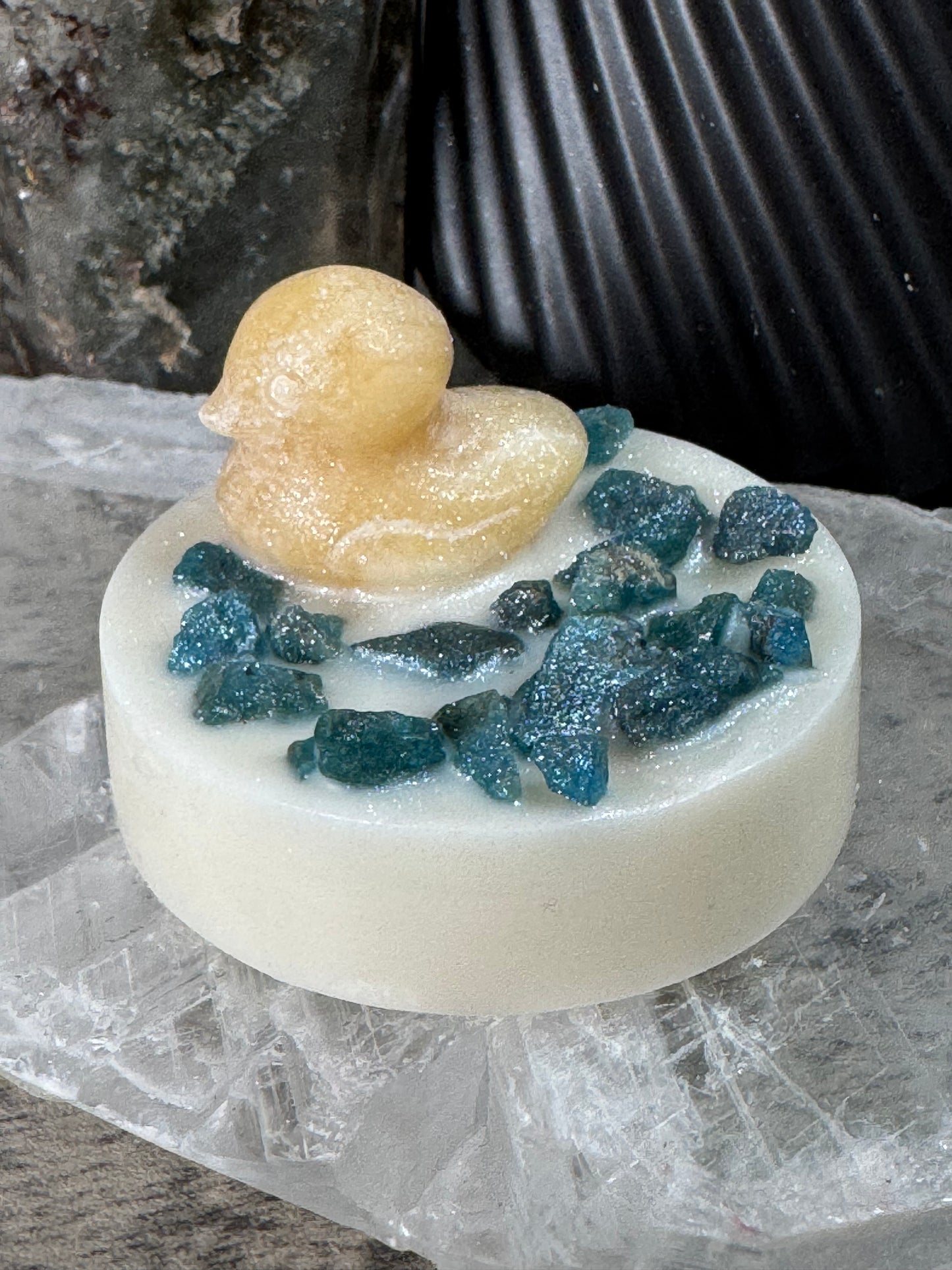 Bar of soap with blue and beige elements on a textured surface