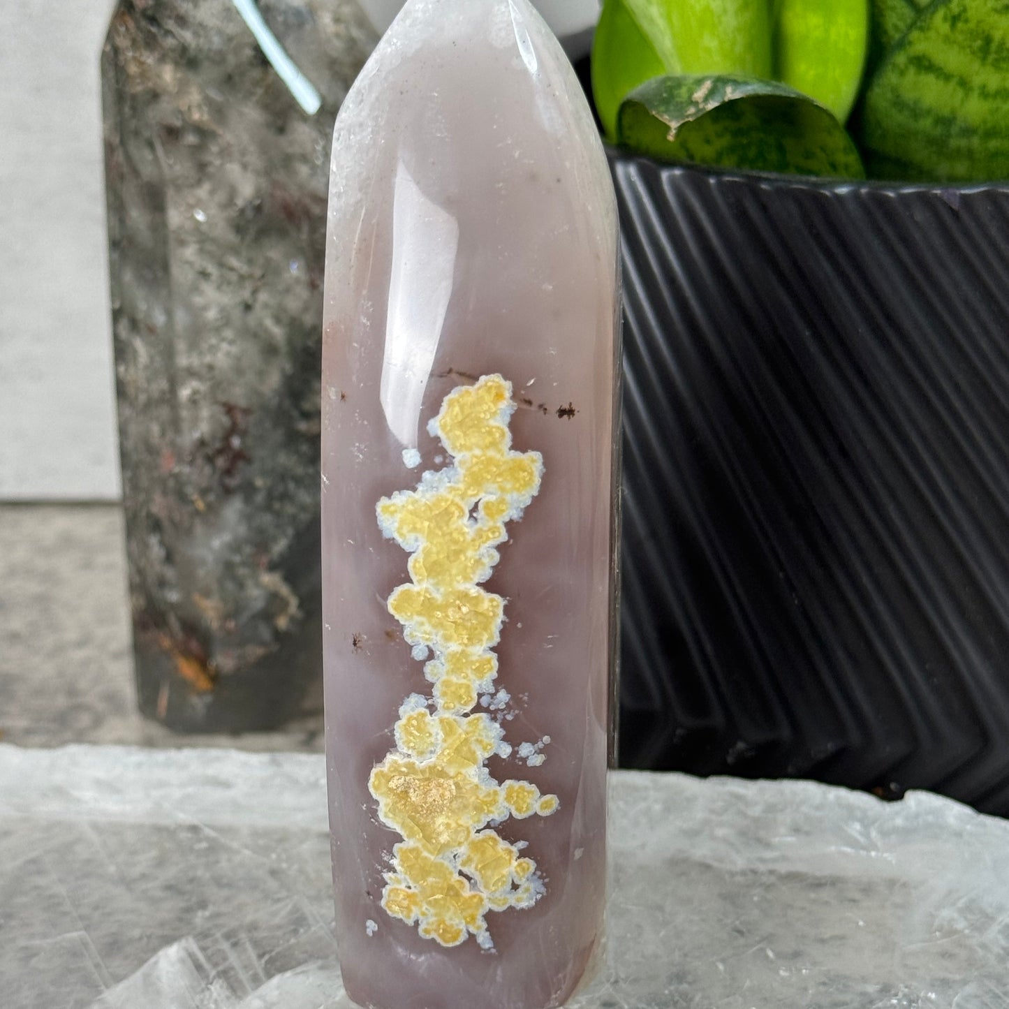 Crystal with yellow crystals on a reflective surface