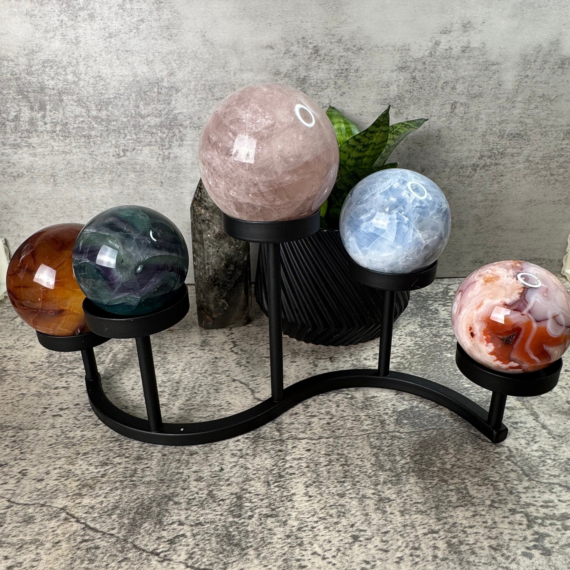 Decorative stand with spherical stone ornaments on a concrete surface