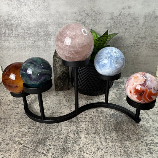 Decorative stand with spherical stone ornaments on a concrete surface